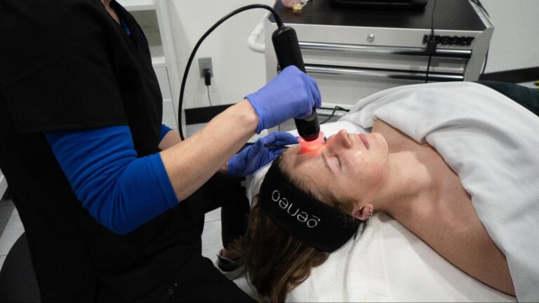 A professional aesthetician applying a soothing mask during an acne facial session in Fargo ND