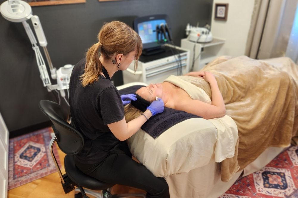 An esthetician providing a professional dermaplaning treatment to a client at Uptown Haven in Fargo ND.