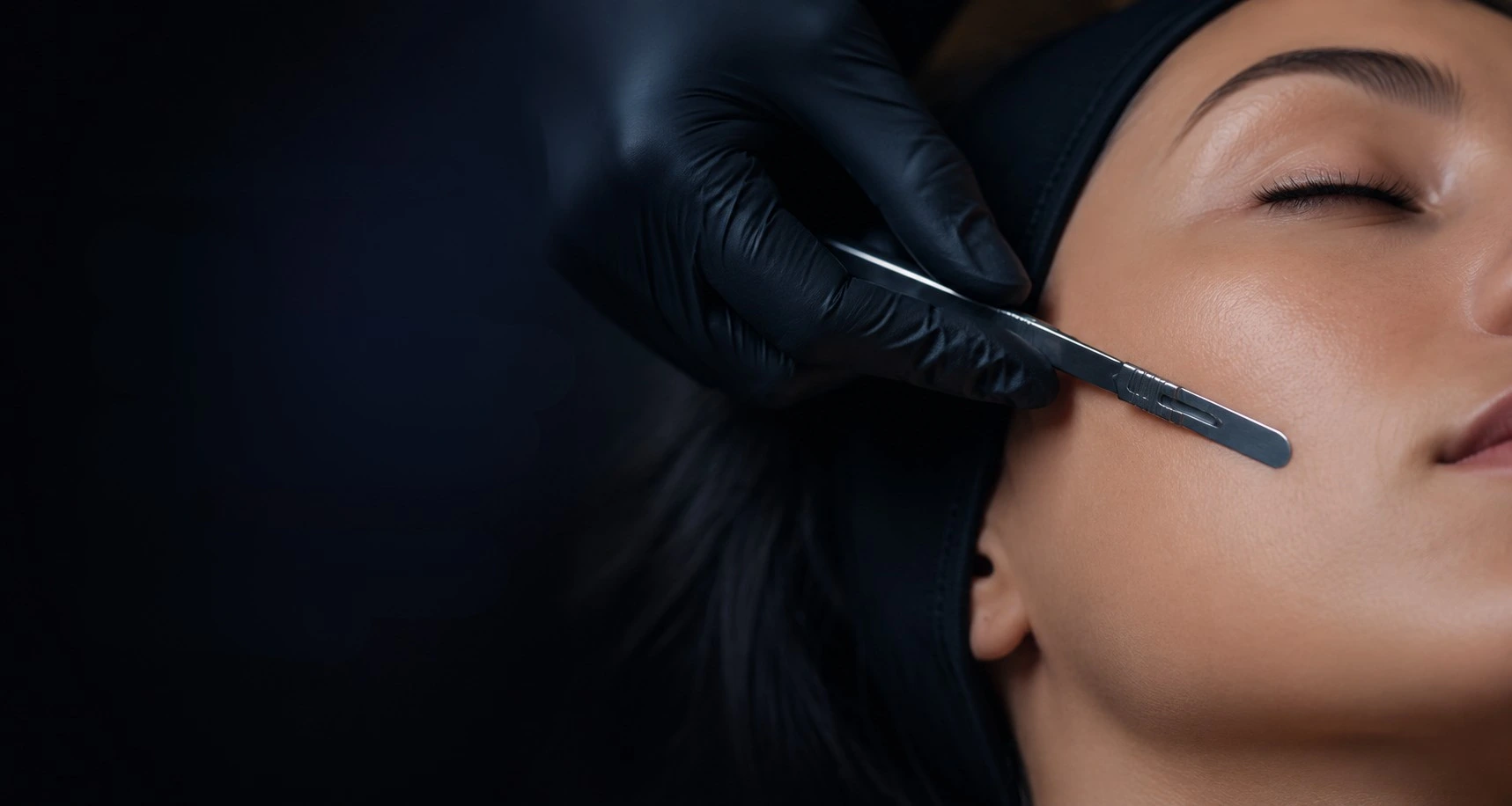 An esthetician performing a professional dermaplaning treatment on a client at Uptown Haven in Fargo