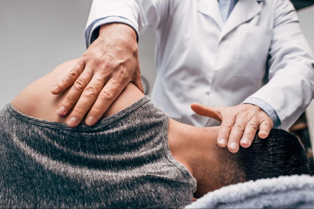A doctor performing a spinal alignment as part of a comprehensive massage and chiropractic adjustment session.