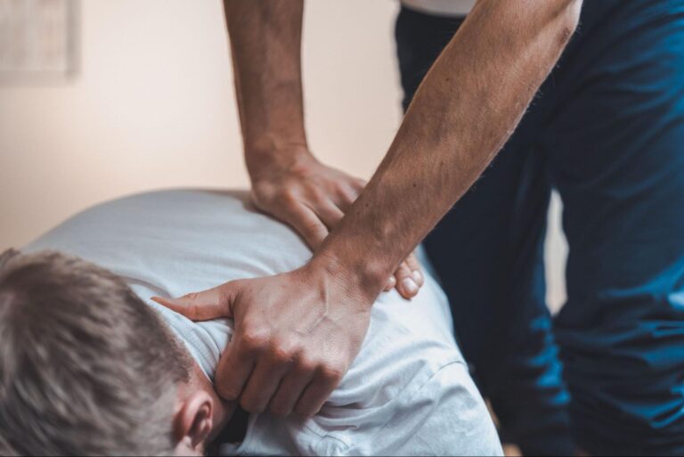Chiropractor adjusting a client's upper back and neck.