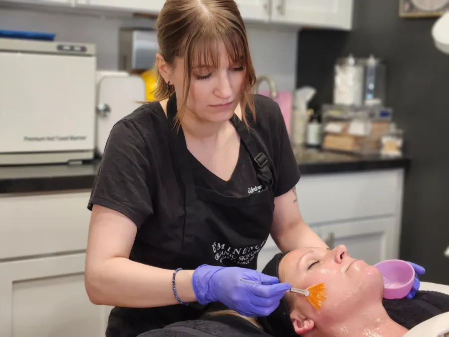 Esthetician applying a facial treatment to a client
